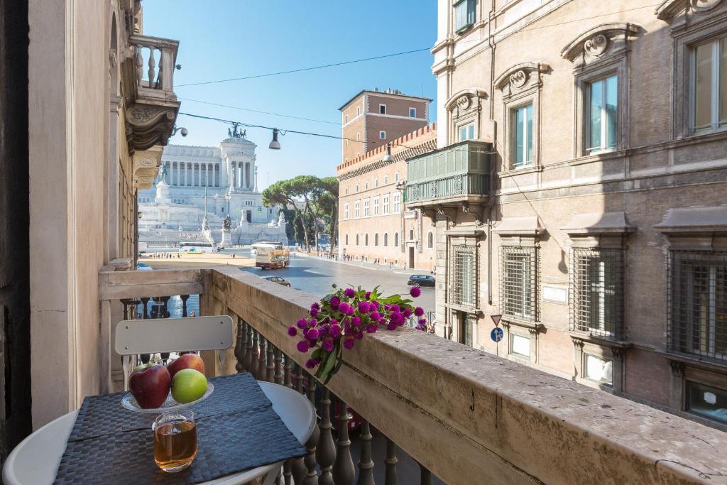 einen Tisch mit Äpfeln und Blumen auf dem Balkon in der Unterkunft Amazing Piazza Venezia Suites in Rom