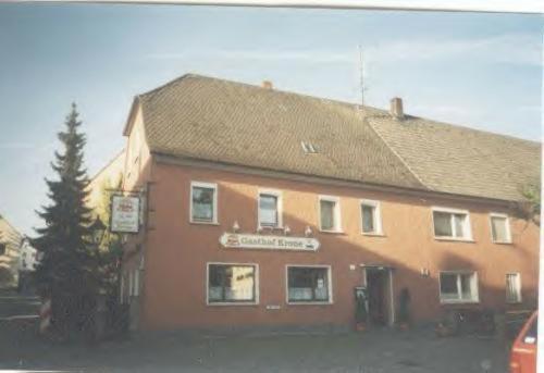 un gran edificio marrón con un cartel. en Gasthof zur Krone, en Burghaslach