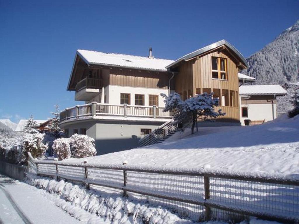 a house is covered in snow with a fence at Haus Schröcker in Gaschurn