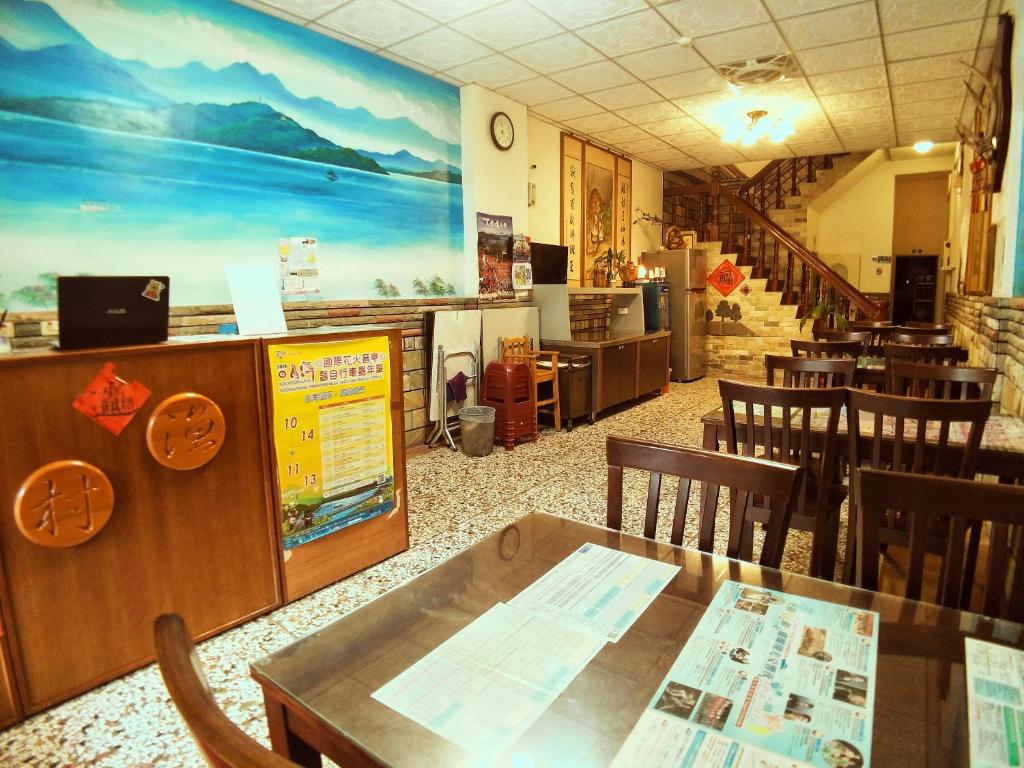 a restaurant with a table and chairs in a room at Sun Moon Lake Fisherman Homestay in Yuchi
