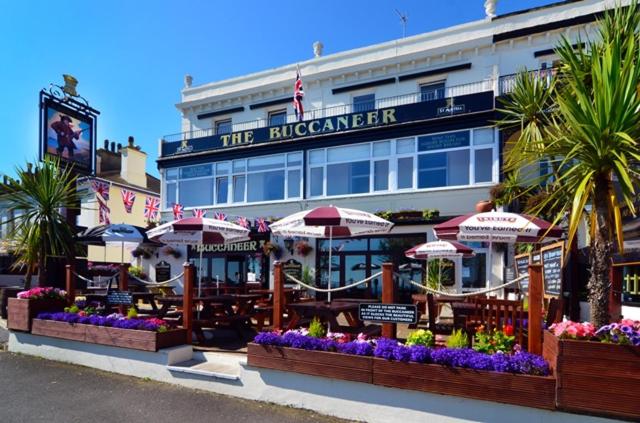 托基的住宿－The Buccaneer Inn，一座建筑前面有雨伞和鲜花