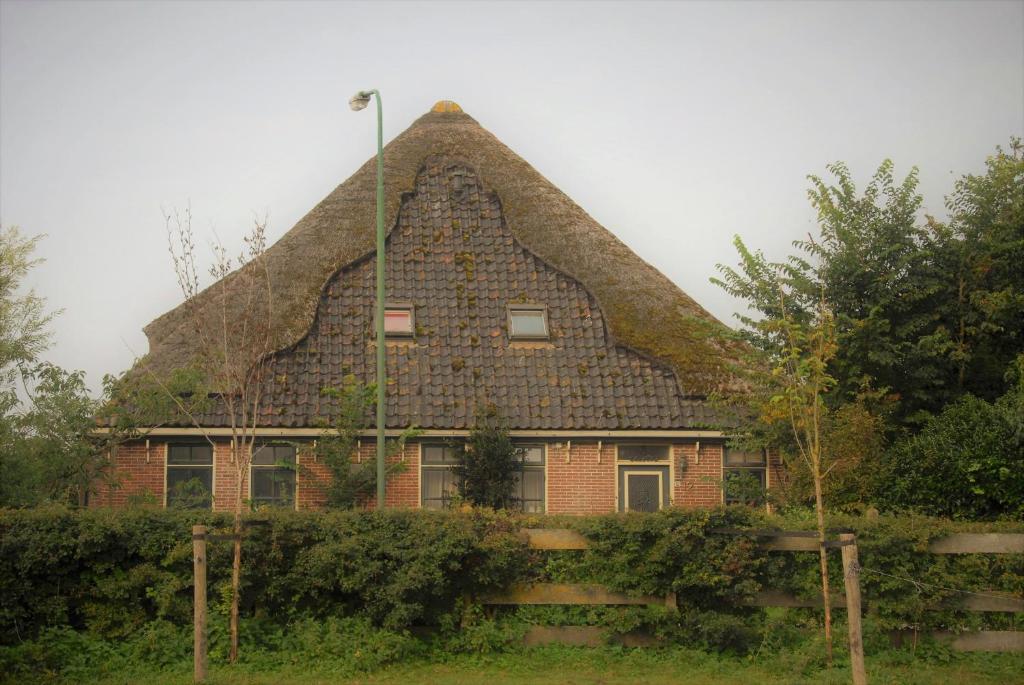 een groot huis met een rieten dak bij Sterrenhoeve in Castricum