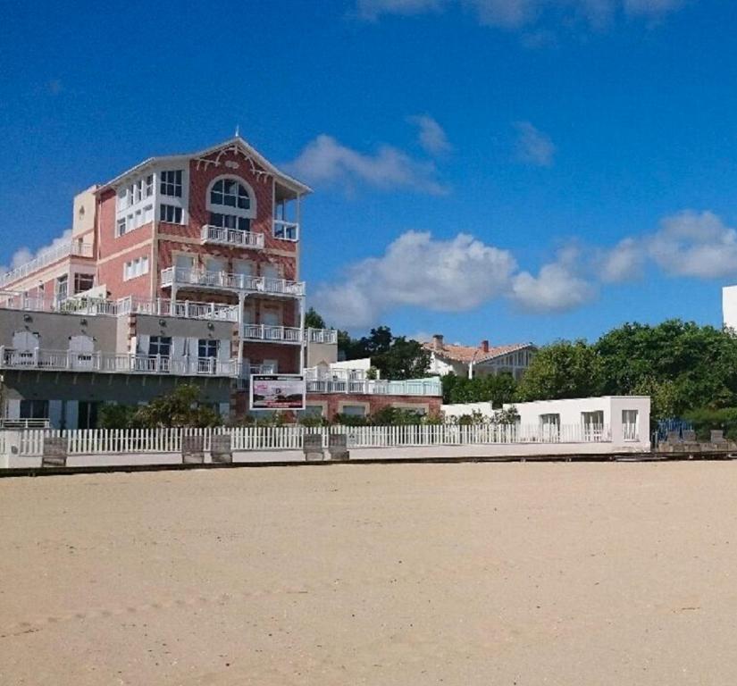 a building with a white fence in front of a beach at Residence vue de reve - 1 ere ligne de plage in Arcachon