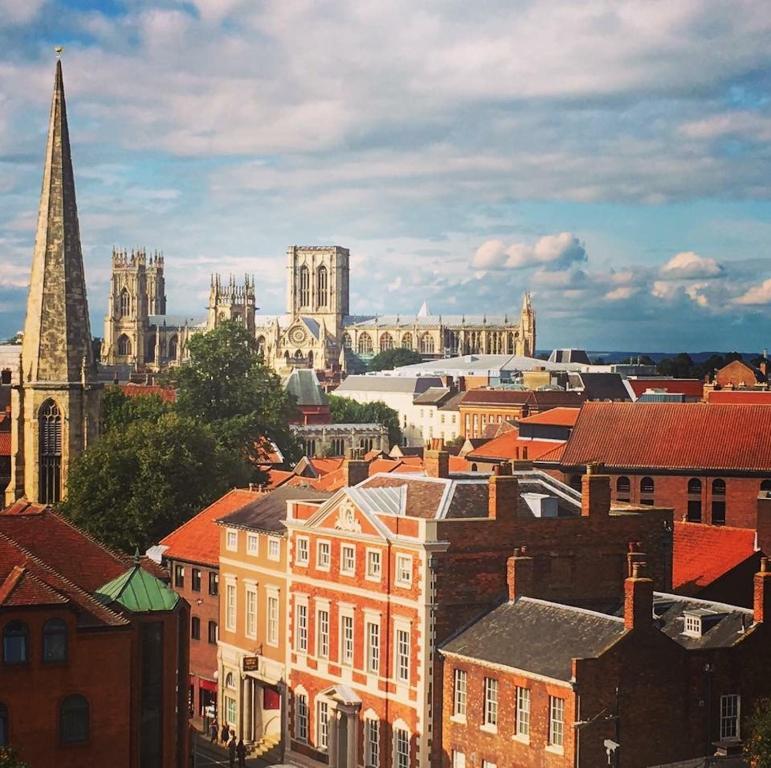 a view of a city with a cathedral and buildings at Cosy Victorian Apartment - Central York in York