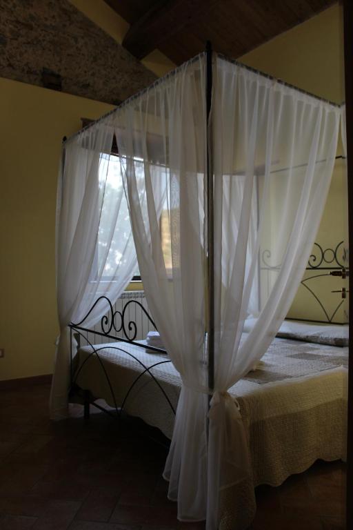 StiloにあるAgriturismo Casato Ruggeroのベッド(上部に白いカーテン付)