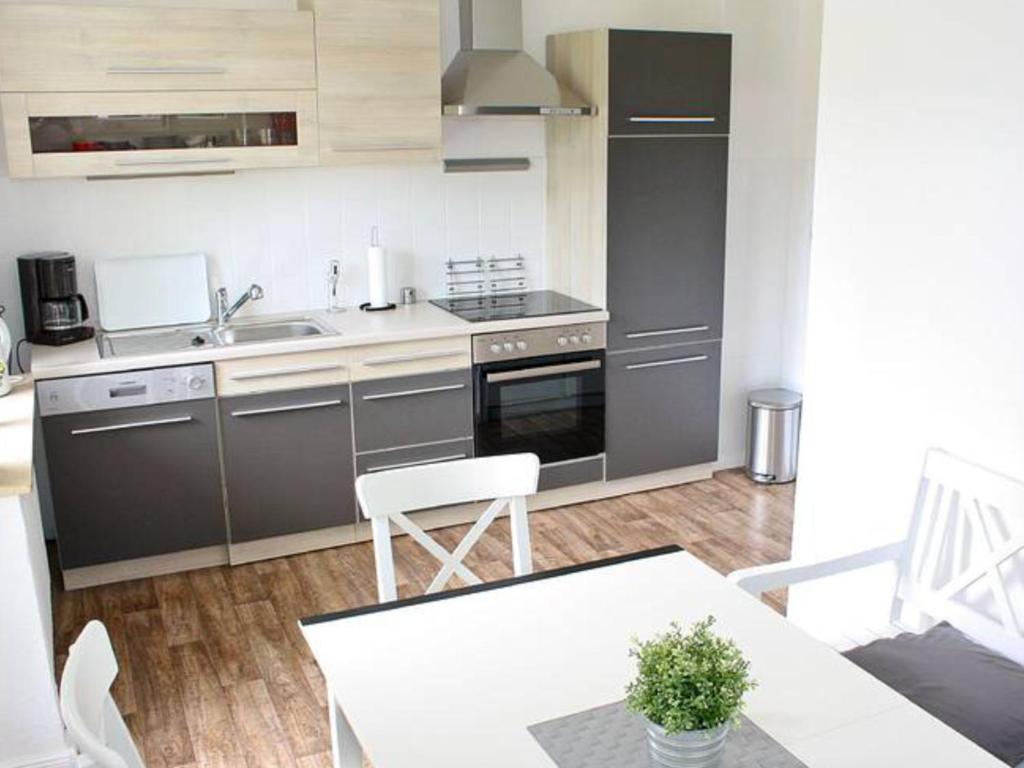 a kitchen with stainless steel appliances and a table at Dat Ferienhus in Bad Zwischenahn