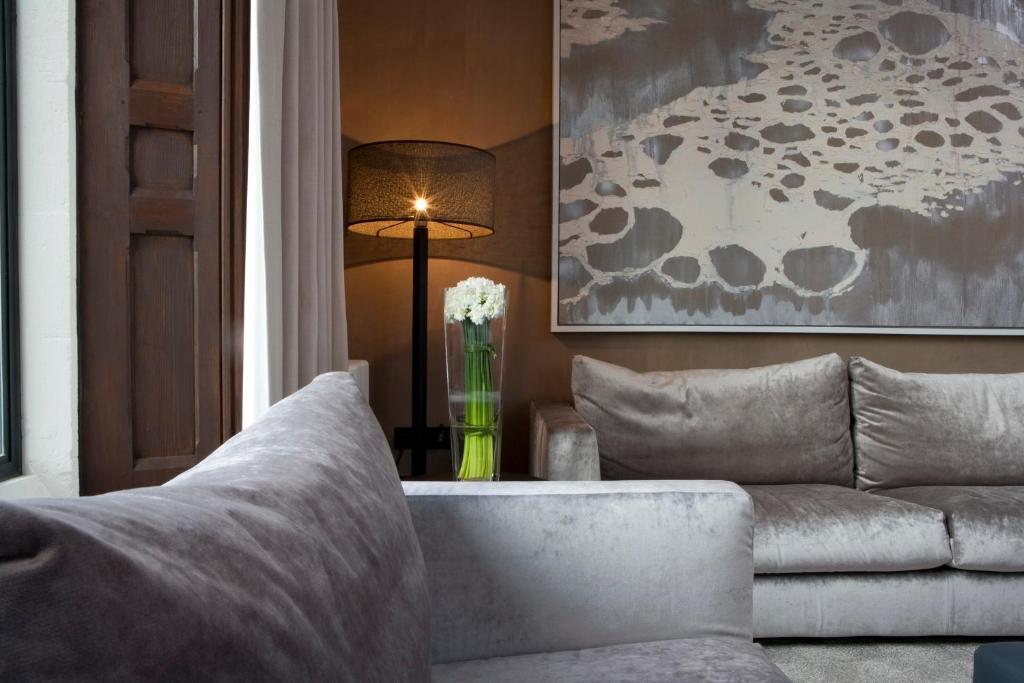 a living room with a couch and a table with a lamp at Penrhiw Priory in St. Davids