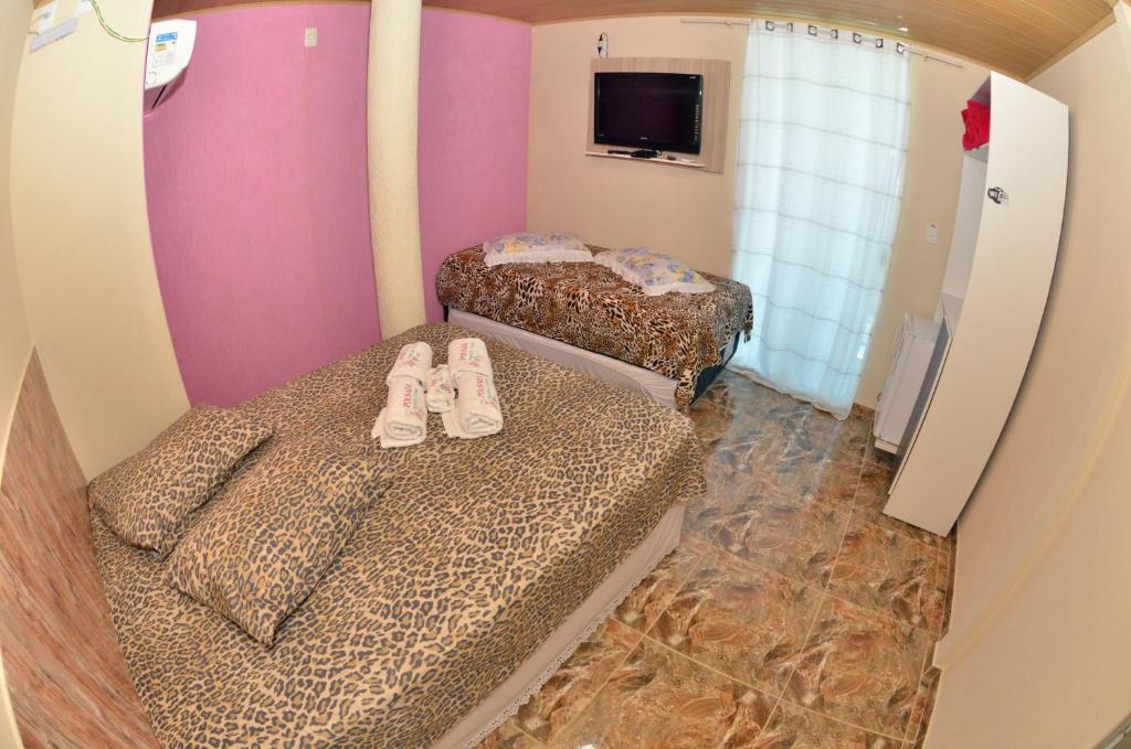 Dos camas con zapatos en una habitación en Pousada Família Flores, en Penha