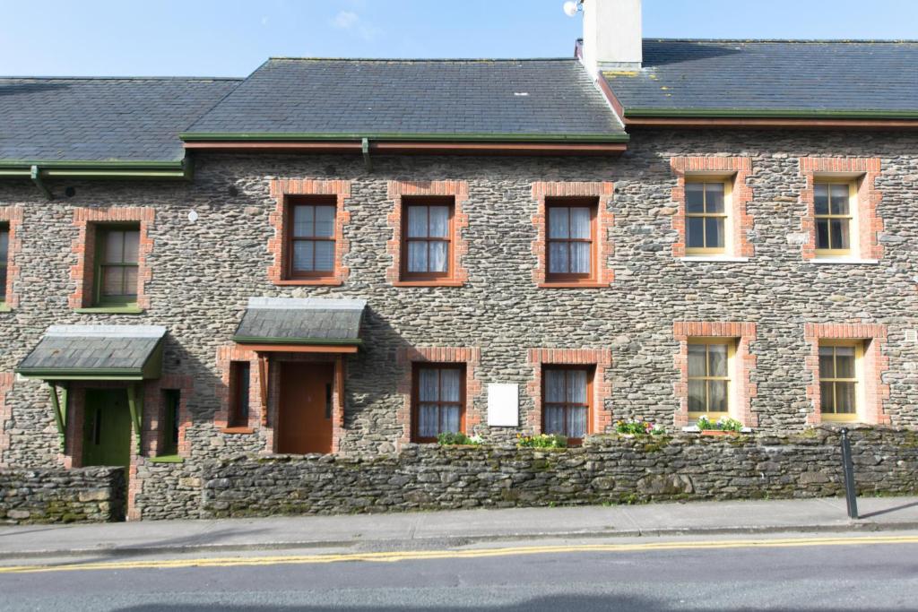 a brick building with windows and a stone wall at Burnham View in Dingle