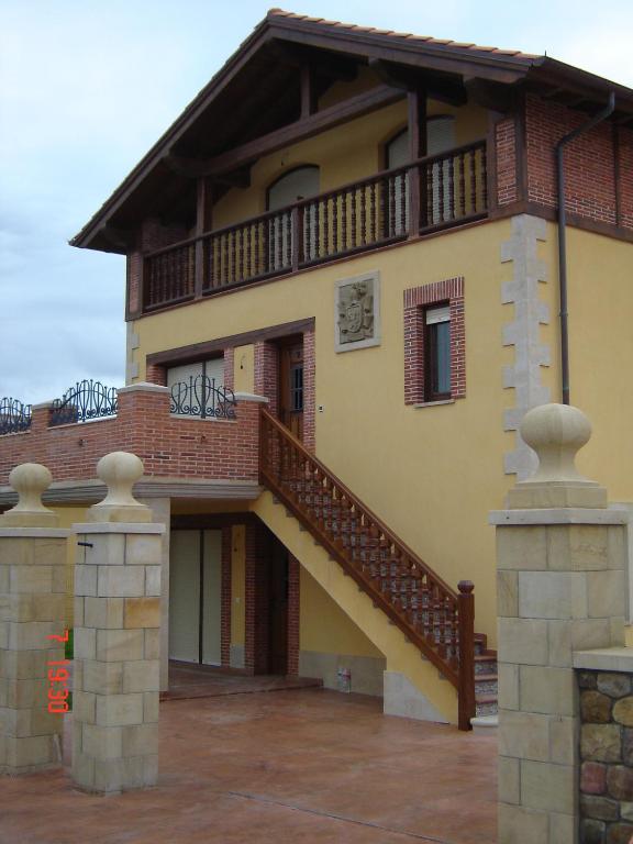 a large house with a staircase in front of it at Apartamentos Antonio in Ubiarco