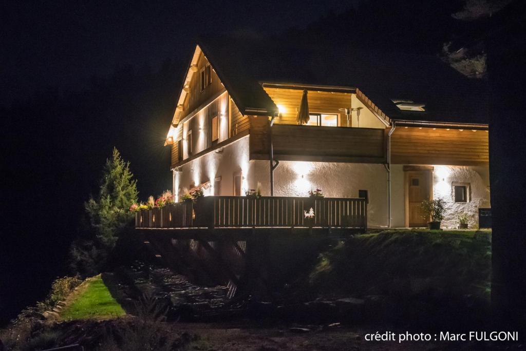 uma casa à noite com luzes acesas em La Ferme du Nol em La Bresse