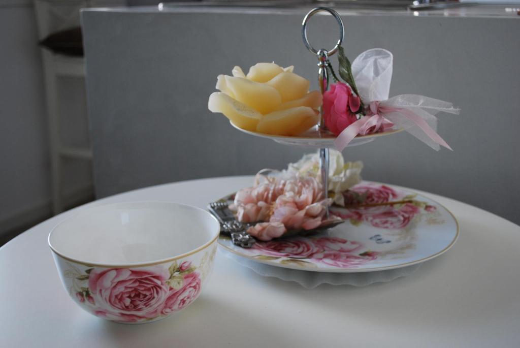 una mesa con una taza de té y un tazón de flores en Casa Polly B&B, en Grottammare