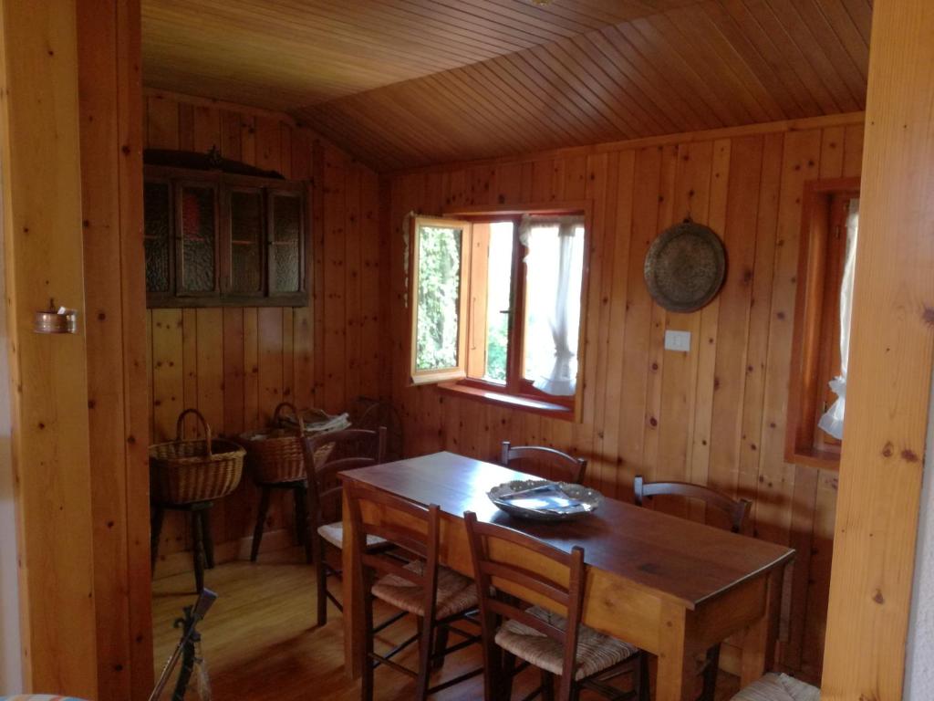 una sala da pranzo con tavolo e sedie in legno di Casa nei boschi della Val Bormida a Calizzano