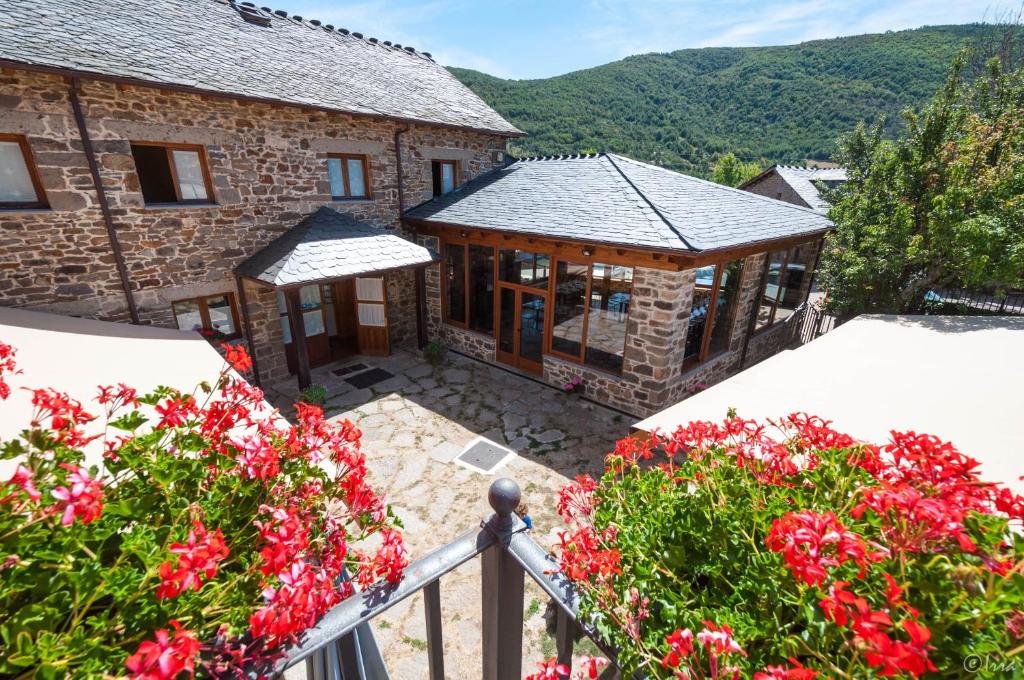 una imagen de una casa con flores delante en Hotel Rural La Bolera, en Robles de Laciana