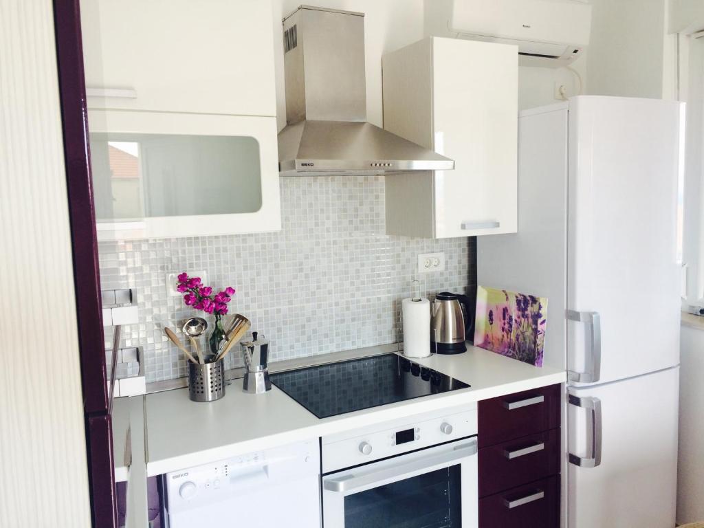a kitchen with white cabinets and a stove top oven at Apartments Baričević in Bol