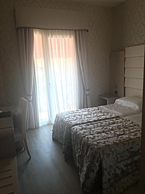 A bed or beds in a room at Hotel Capri Bardolino 3S