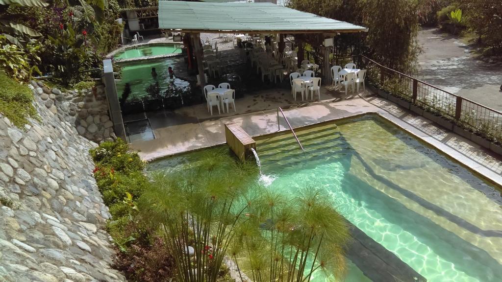 an overhead view of a pool with chairs and a house at Hotel Termales Tierra Viva in Manizales