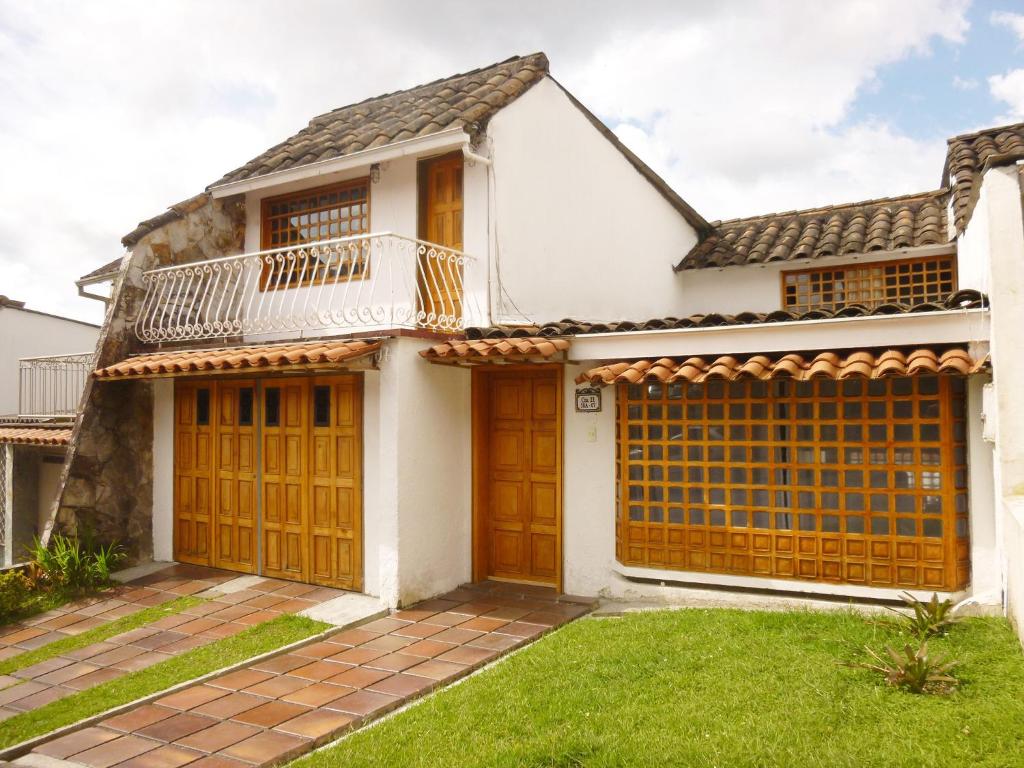 a house with wooden doors and a balcony at Hostal Café Casa Caturro in Manizales