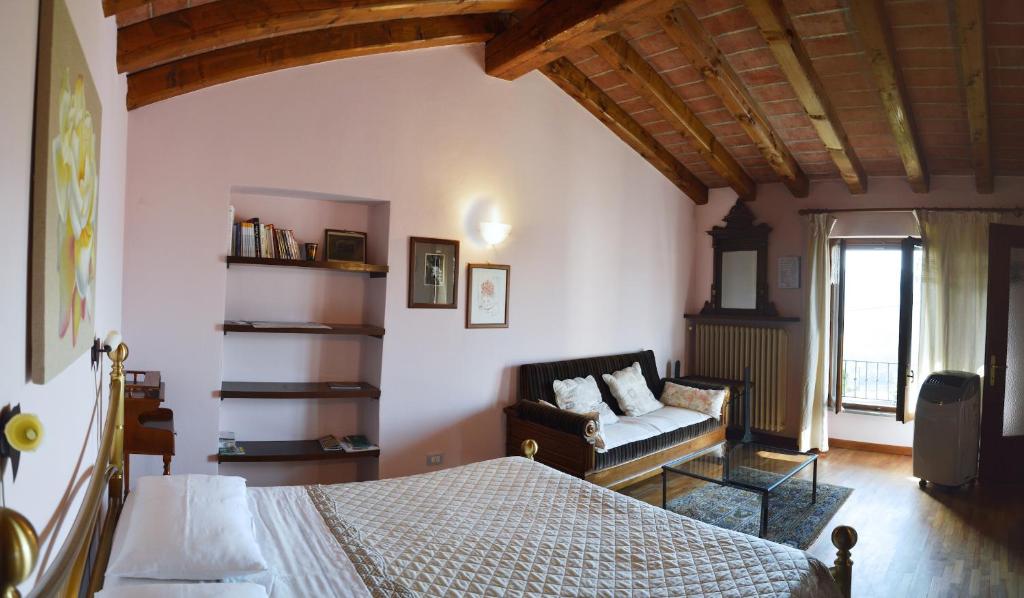 アルバにあるI Tigli di Altavillaのベッドルーム1室(ベッド1台、ソファ付)