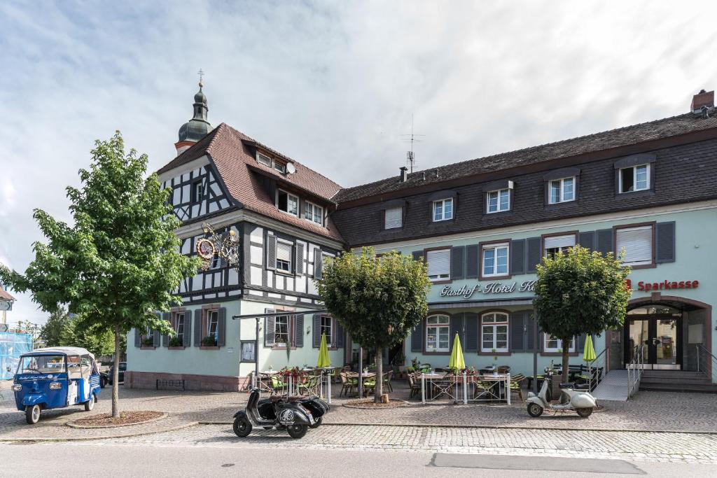 een gebouw met motoren die ervoor geparkeerd staan bij Gasthof - Hotel Kopf in Riegel