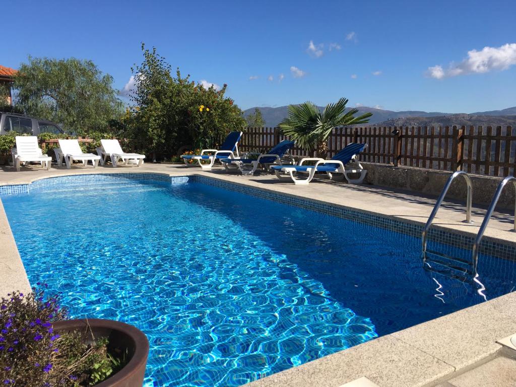 una piscina con sillas azules en Casa de Mos, en Aboim
