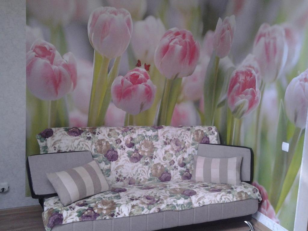 セルプホフにあるАпартаментыのピンクの花の壁の前のソファ