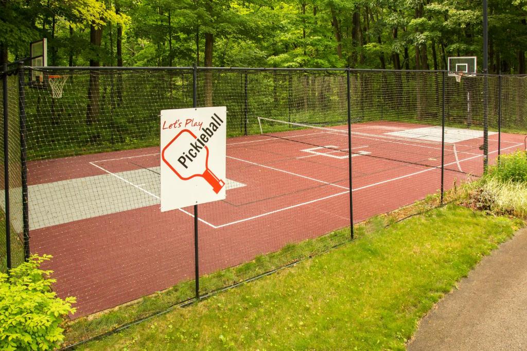 a tennis court with a sign on a fence at Hidden Serenity Bed and Breakfast in West Bend