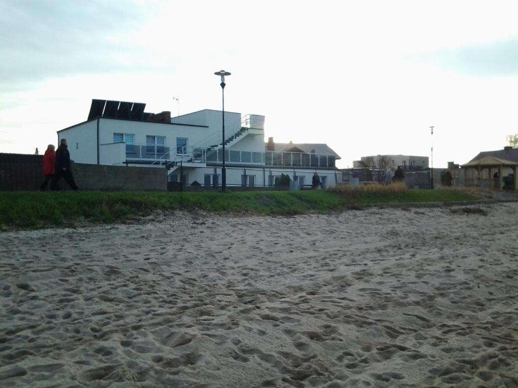 een zandstrand met een huis op de achtergrond bij Willa Aster in Rewa