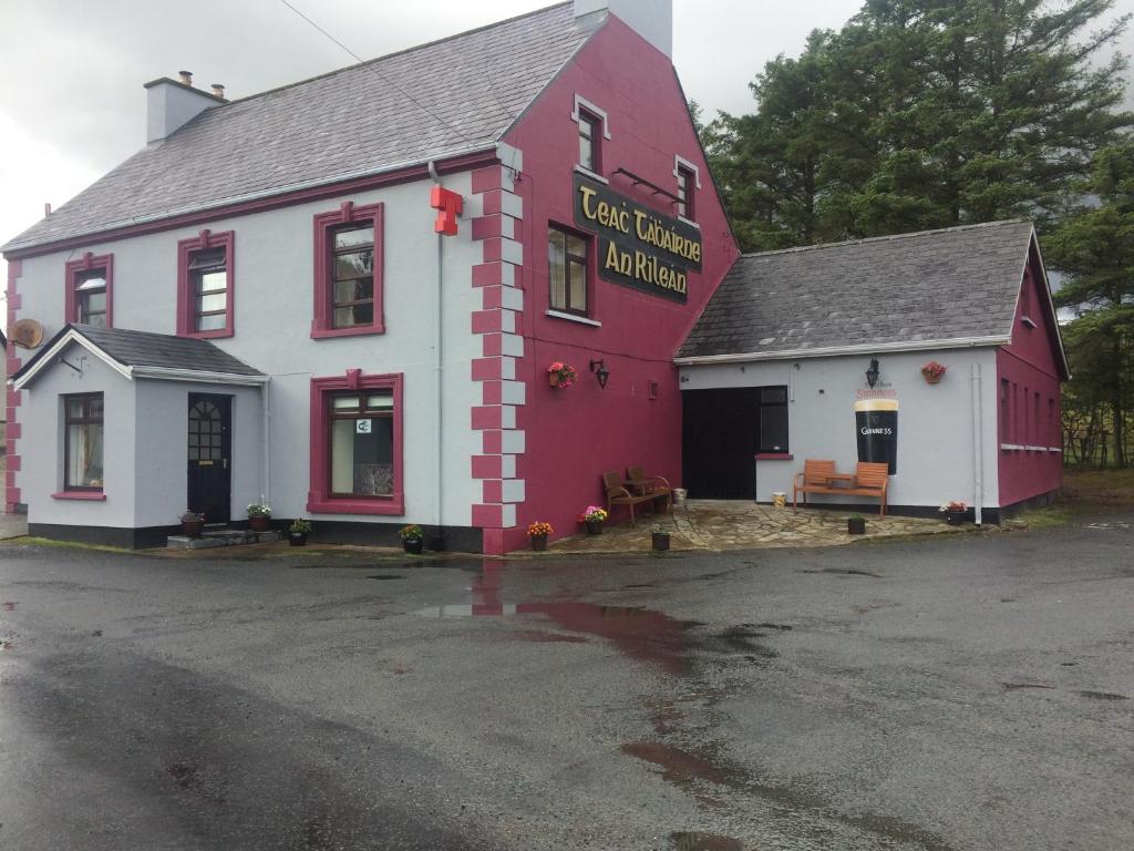 a red and white building in a parking lot at Reelin bar holiday Accommodation in Cloghan