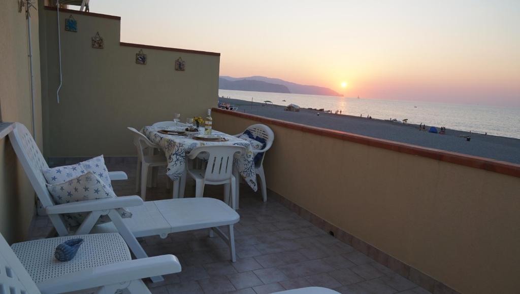 een balkon met een tafel en stoelen en uitzicht op het strand bij Stella Marina in Terme Vigliatore