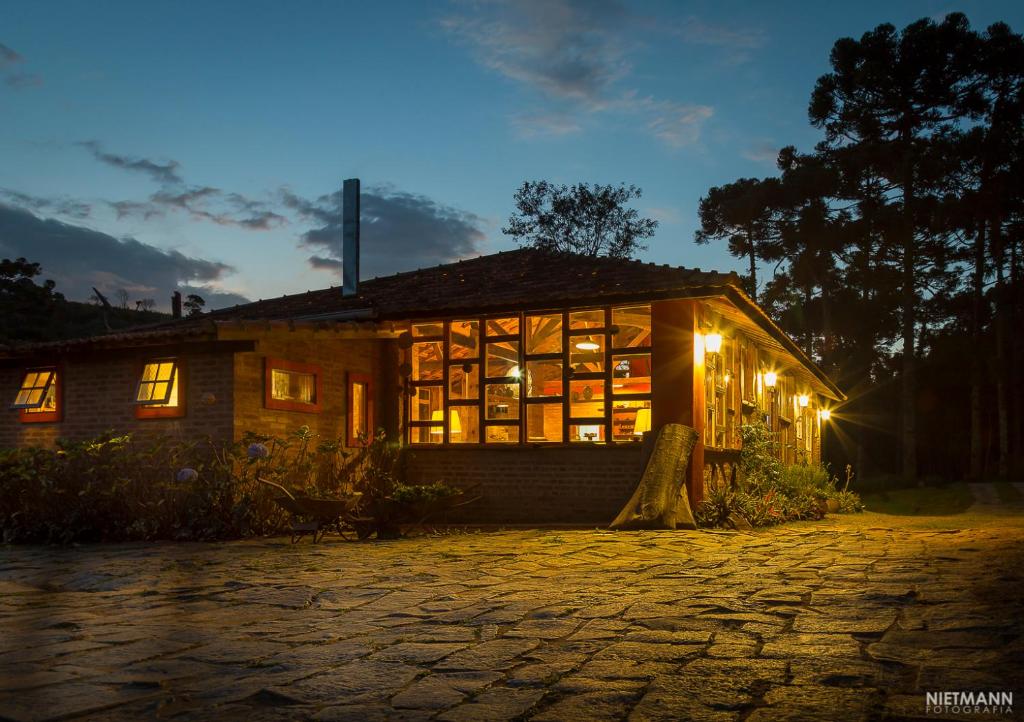uma casa iluminada à noite com luzes em Pousada da Oma em Cunha