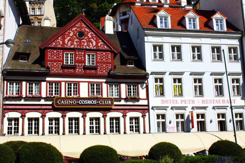 a large red and white building in a city at Hotel Petr in Karlovy Vary