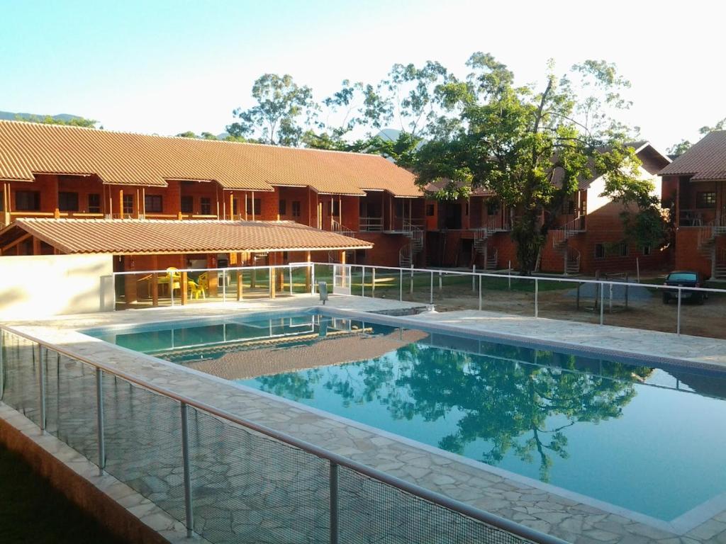 a swimming pool in front of a building at Casa De Praia Maranduba in Ubatuba