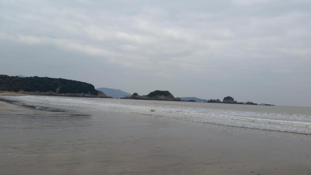 una playa con un cuerpo de agua con árboles en 舟山朱家尖东沙东和梦园民宿, en Zhoushan