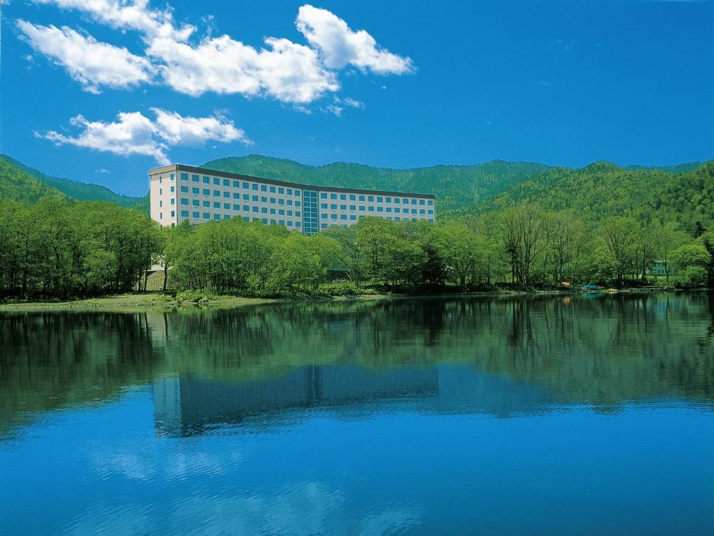 a large building sitting next to a large body of water at Kussharo Prince Hotel in Teshikaga