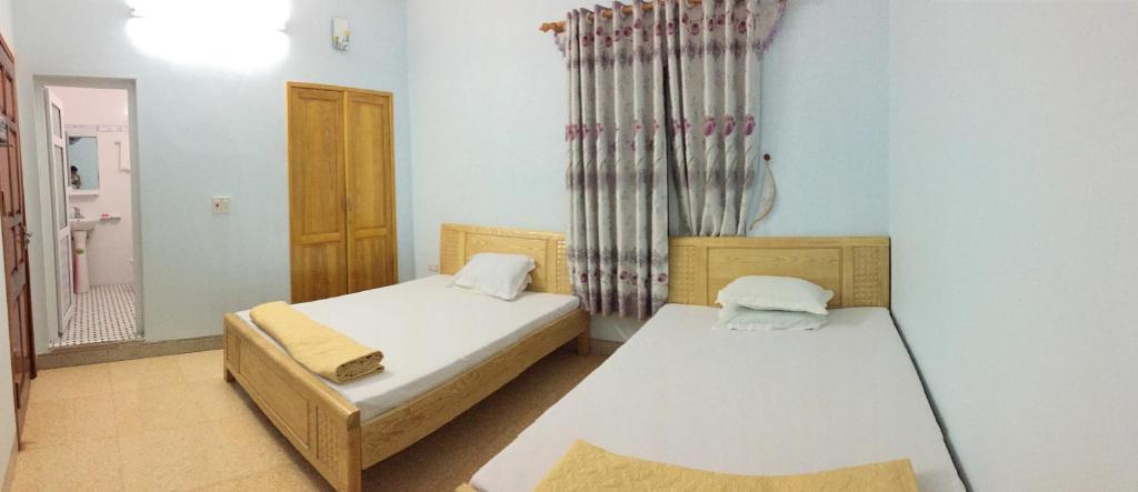 a small room with two beds and a window at Tuân Thuỷ hotel đảo Quan Lạn in Quan Lạn