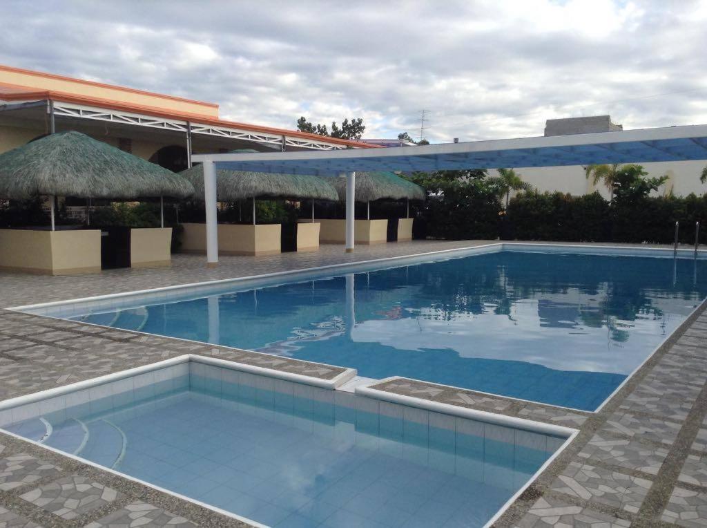una piscina en un complejo con un edificio en UKL Ever Resort Hotel, en Laoag