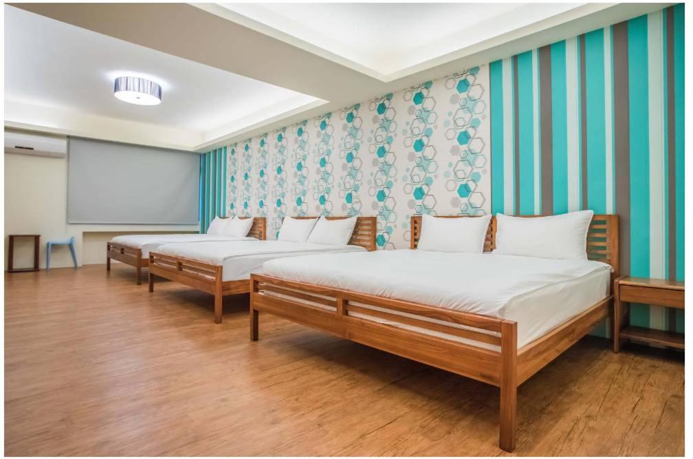 東港的住宿－藍鷺鷥民宿，配有黑板的房间的两张床