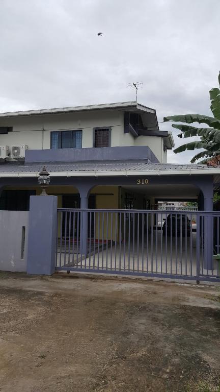 a white building with a gate in front of it at Ellis Lot 310 in Kuching