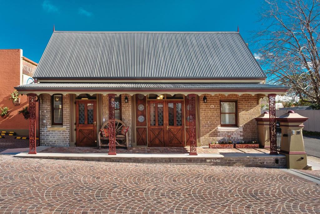 a small brick house with a metal roof at Old Bank Boutique Hotel in Mittagong