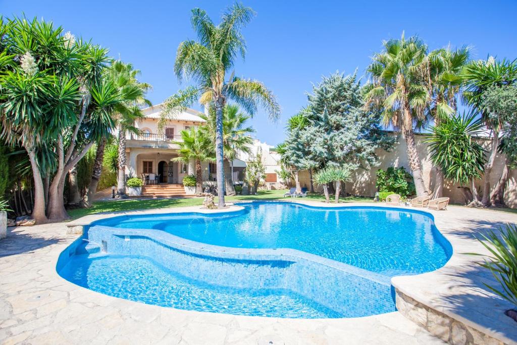 een zwembad in een tuin met palmbomen bij Can Gual in Inca