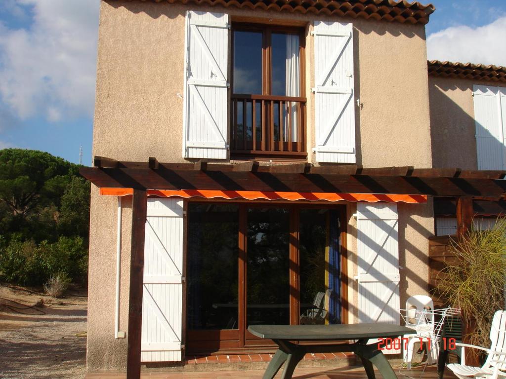 uma casa com uma mesa de piquenique em frente em Les Bastidons em Sainte-Maxime