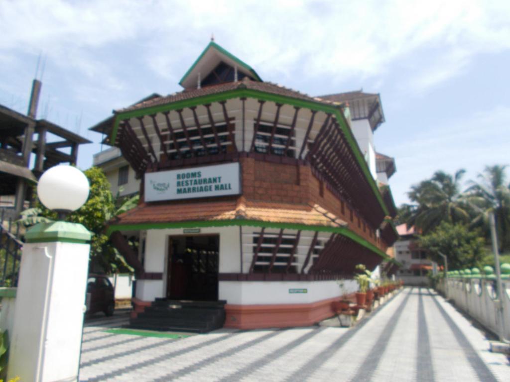 un edificio con un cartel en el costado en KTDC Tamarind Easy Hotel en Guruvāyūr