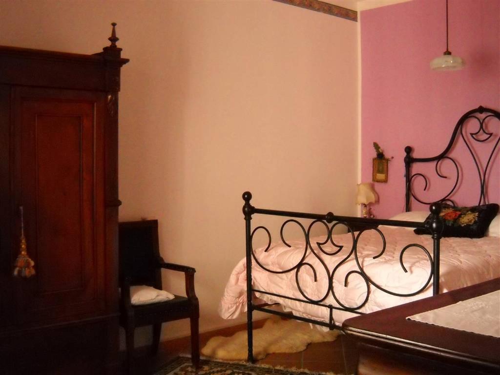 a bedroom with a bed and a chair in a room at B&B ANNA in Forlì