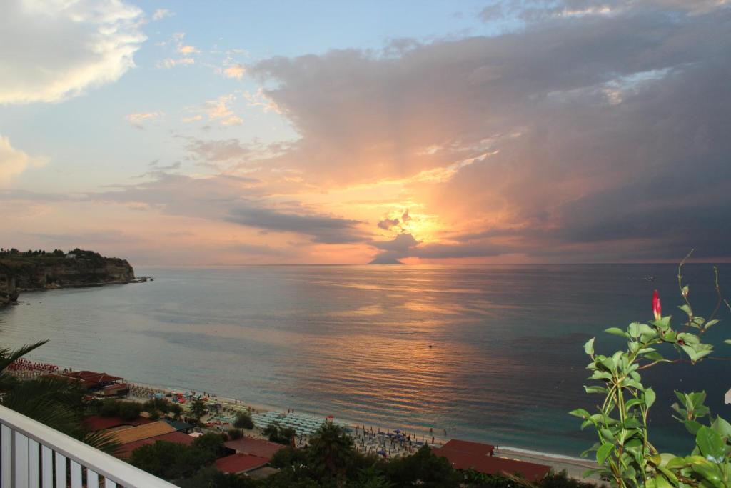a view of the ocean at sunset from a balcony at Hotel Terrazzo Sul Mare in Tropea