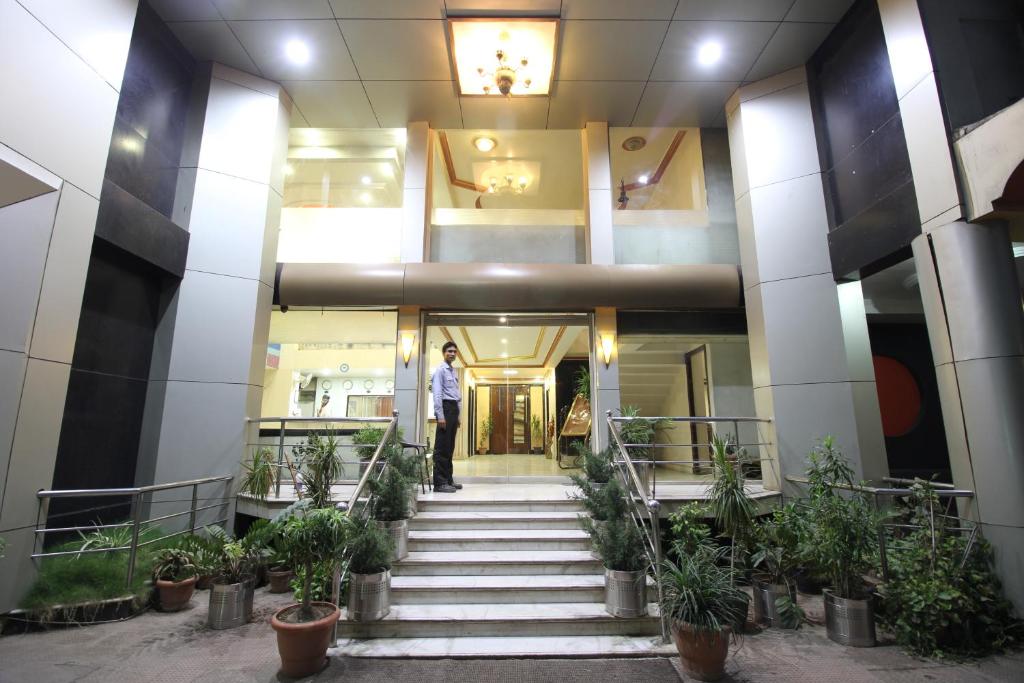 un hombre parado en las escaleras de un edificio en Hotel Grand Arjun, en Raipur