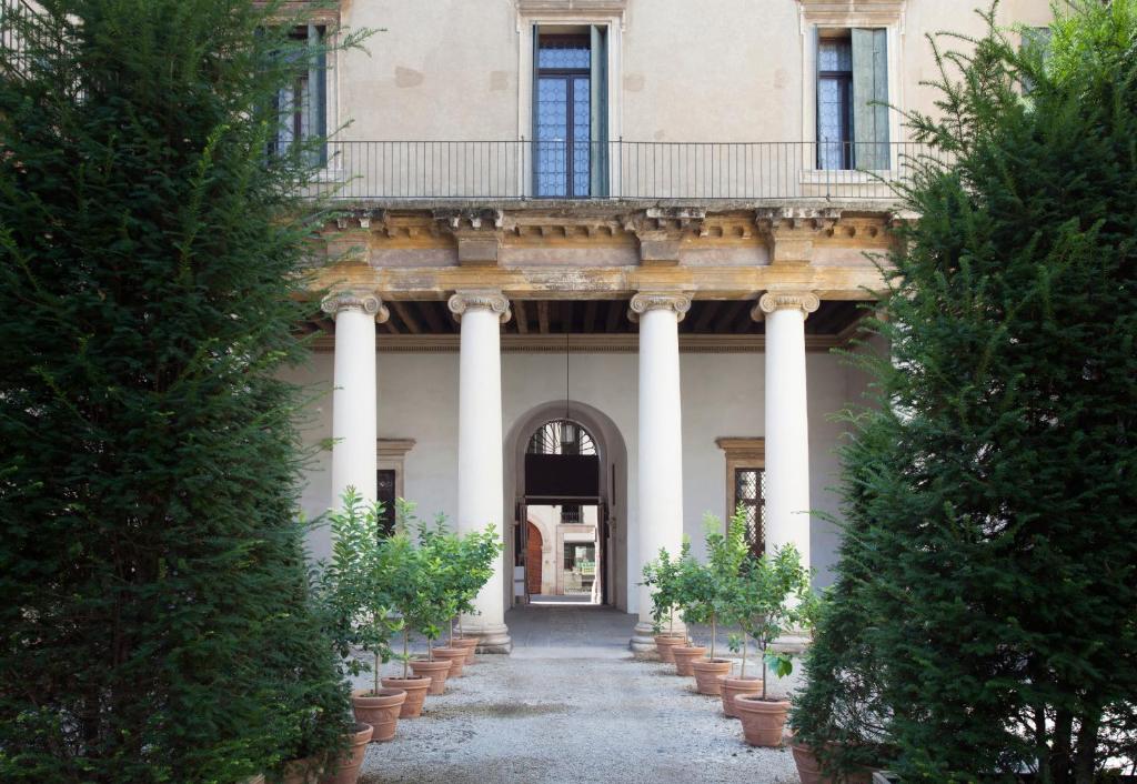 einen Eingang zu einem Gebäude mit Säulen und einem Balkon in der Unterkunft Palazzo Valmarana Braga in Vicenza