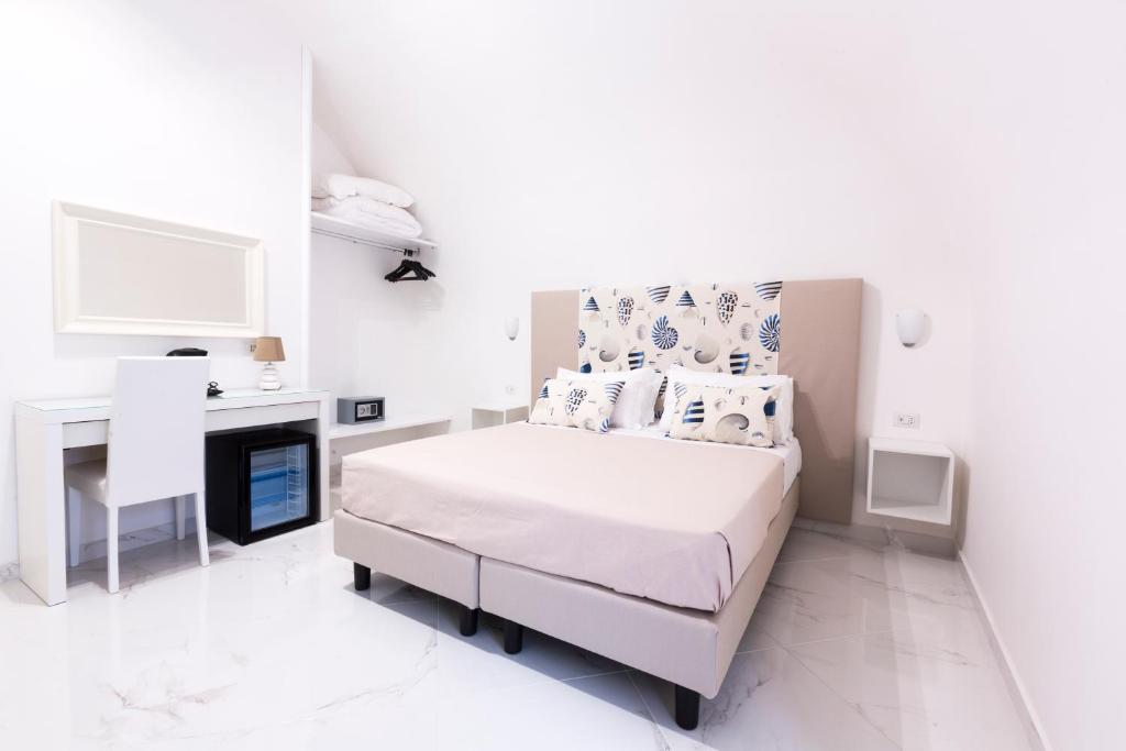 a white bedroom with a bed and a fireplace at Holiday Sorrento Center in Sorrento