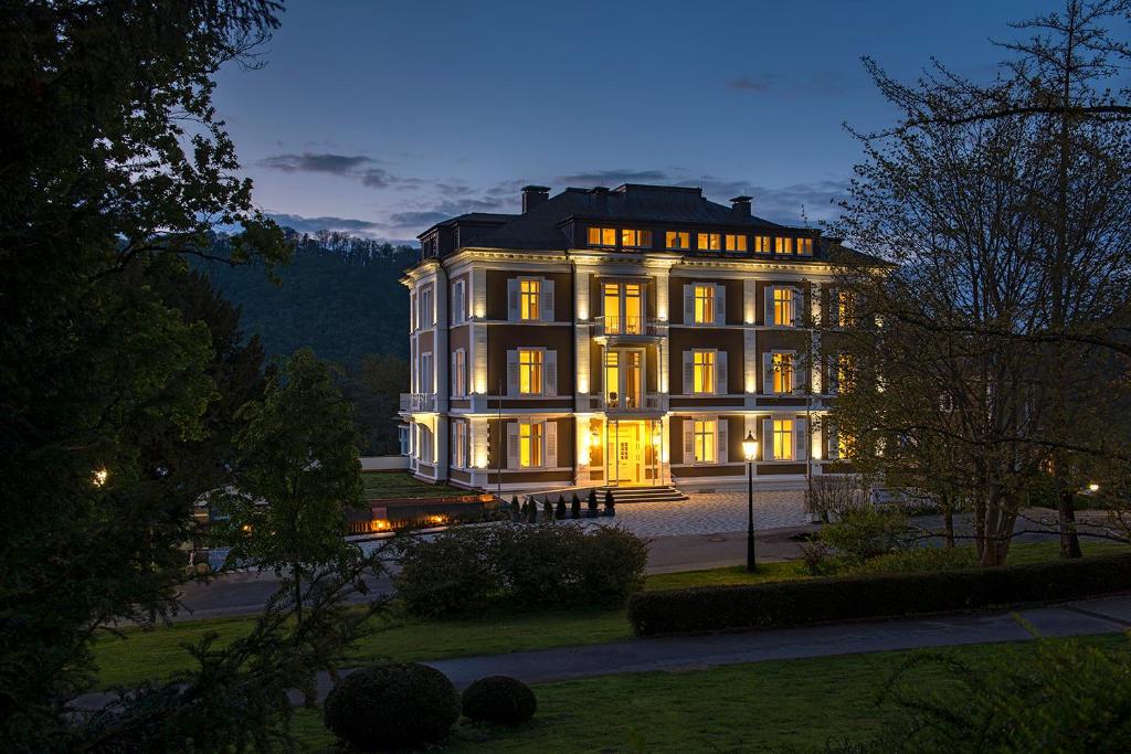 a large building with its lights on at night at Park Hotel & Spa Katharina in Badenweiler