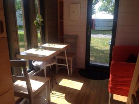 サン・ブノワ・デ・ゾンドにあるvillage insolite tinyのテーブルと窓が備わる小さな客室です。